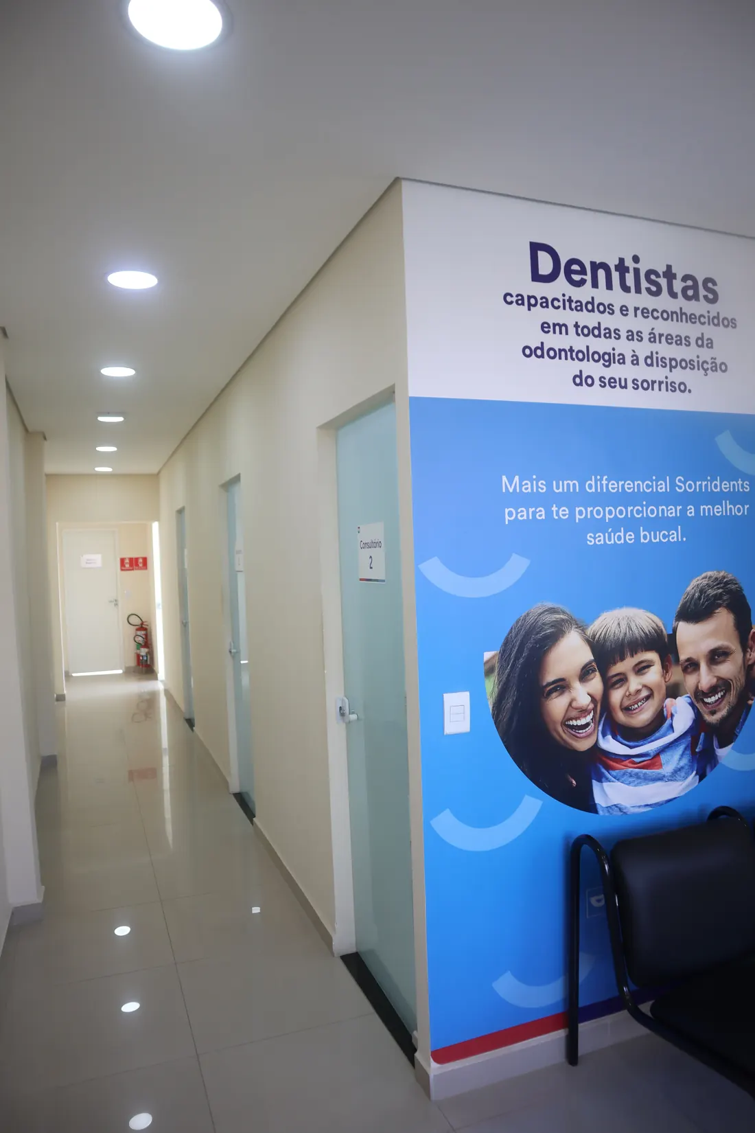 Corredor dos consultórios, com o painel da equipe de dentistas